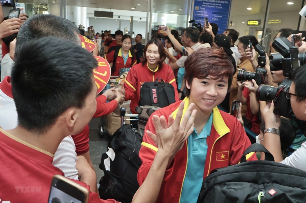 Tuyết Dung và đồng đội trong vòng vây của báo chí và người hâm mộ tại Sân bay Quốc tế Nội Bài. (Ảnh: TTXVN phát)