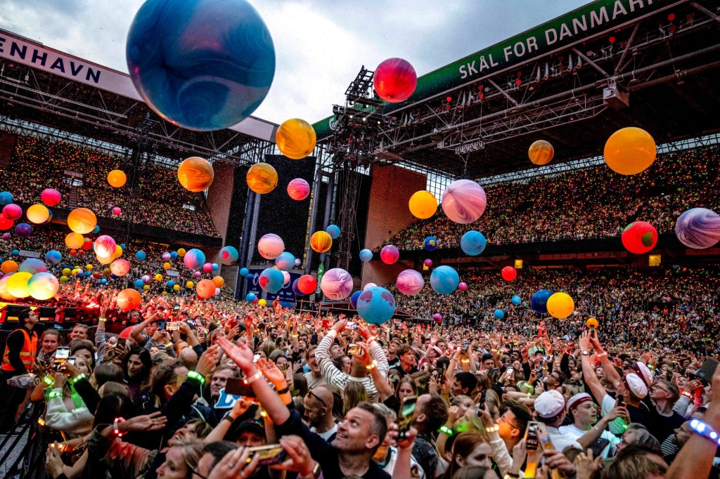 Người hâm mộ cổ vũ khi Chris Martin của Coldplay biểu diễn ở Copenhagen, Đan Mạch. Ảnh: AFP