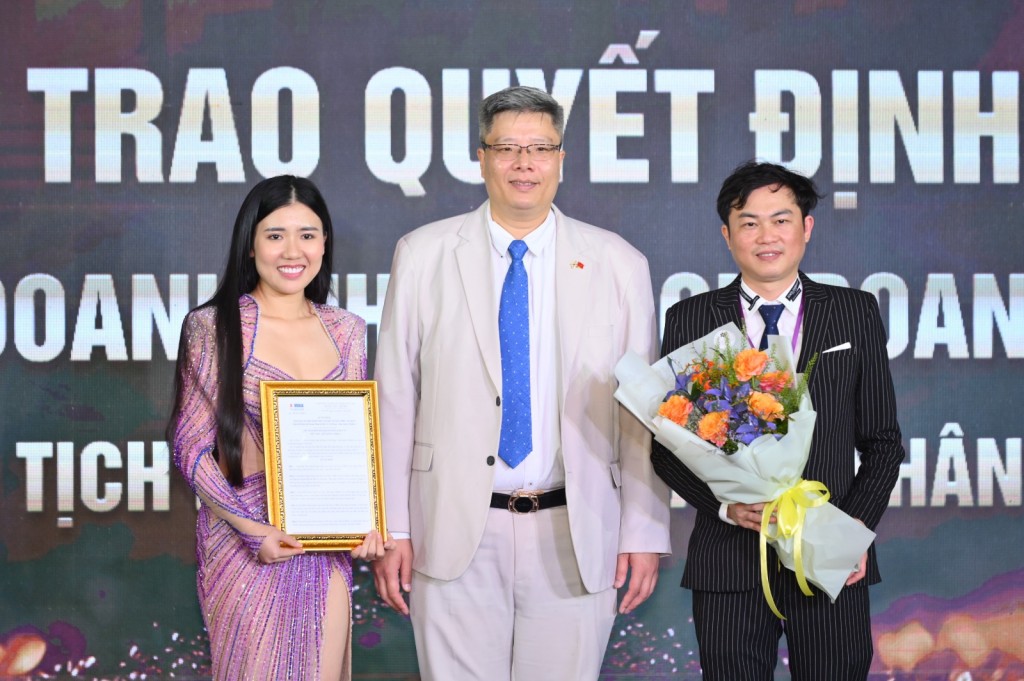 Ông Trần Hải Linh - Ủy viên UBTƯ MTTQ Việt Nam, Chủ tịch Hiệp hội VKBIA tặng hoa và trao quyết định cho đại diện Liên chi hội Doanh nhân làm đẹp Việt Nam (VBBC)