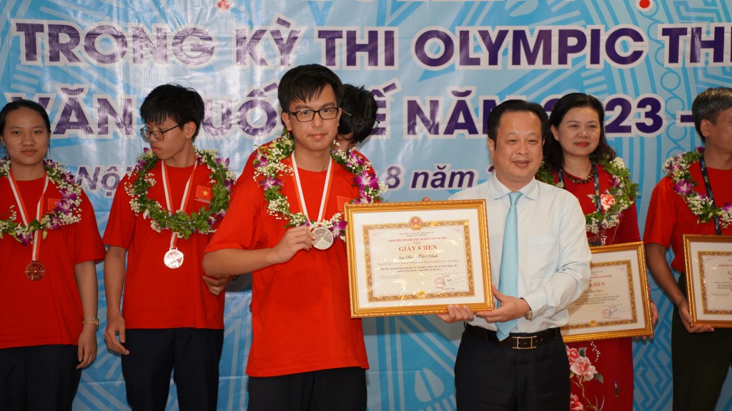 Giám đốc Sở Giáo dục và Đào tạo Hà Nội trao giấy khen cho em Phạm Thế Minh đoạt huy chương Bạc