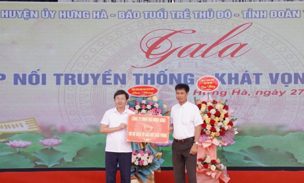 Ông Phạm Hùng Dũng, Giám đốc Công ty Thái Minh Hưng (TP Hồ Chí Ninh)  trao sách cho lãnh đạo Phòng giáo dục Hưng Hà