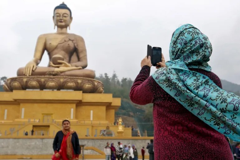 Khách du lịch chụp ảnh bên tượng Phật Dordenma ở thị trấn Thimphu, Bhutan (Ảnh: Reuters)