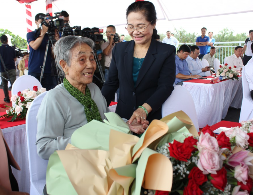 Chủ tịch HĐND TP Hồ Chí Minh Nguyễn Thị Lệ tặng hoa cảm ơn cho cụ bà là người đã chứng kiến suốt quá trình xây dựng cầu trong 23 năm, đã đồng hành cùng chính quyền thành phố trong việc vận động người dân giải phóng mặt bằng