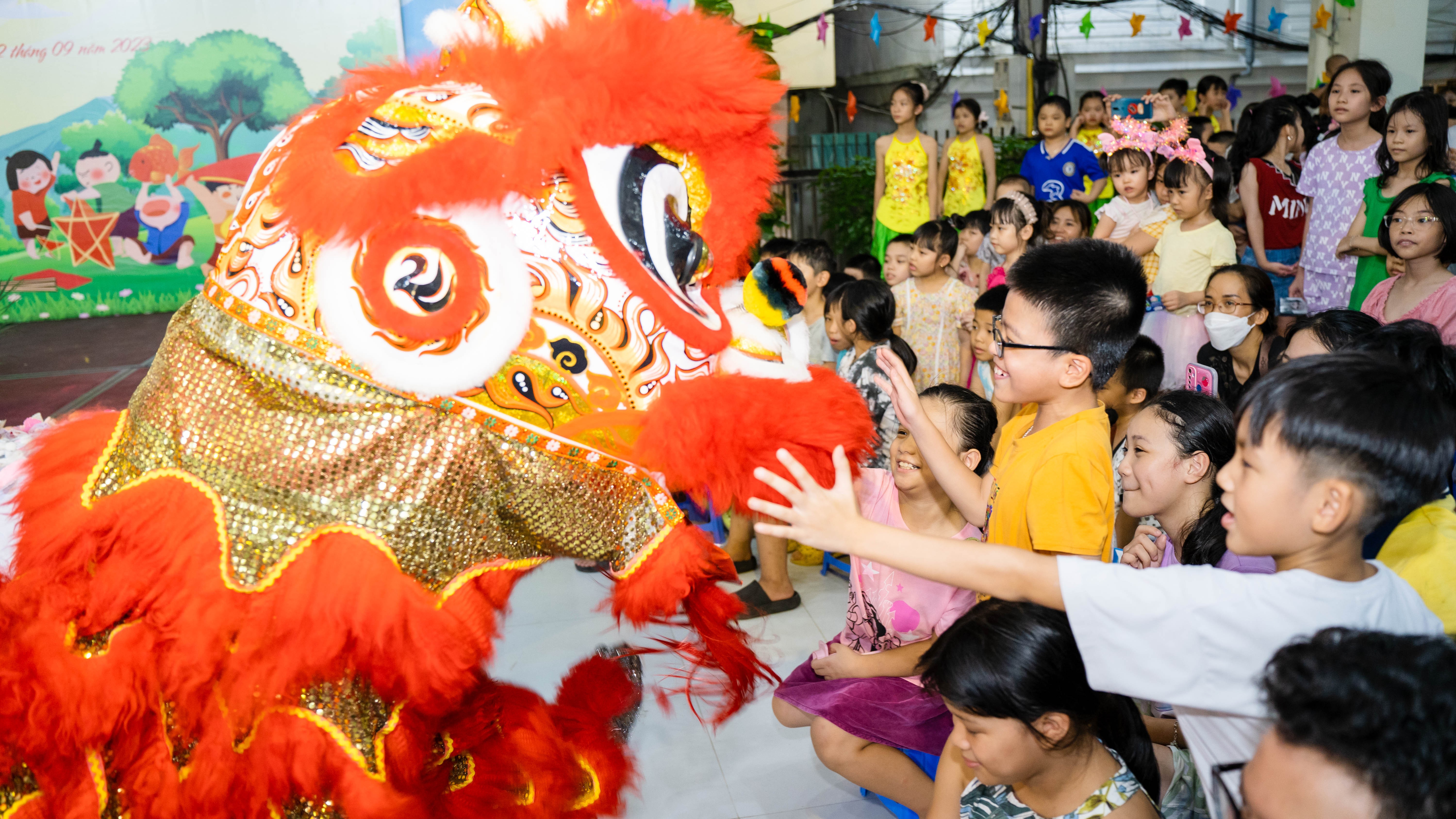 Những em nhỏ thích thú chạm vào con lân