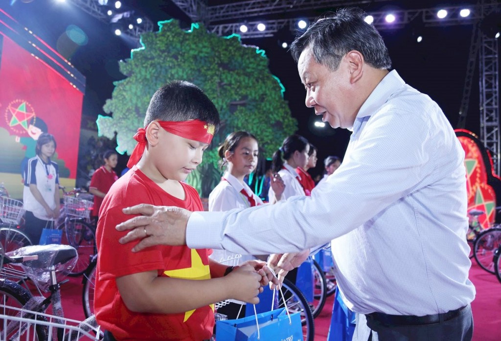 Phó Bí thư Thành ủy Hà Nội Nguyễn Văn Phong trao những phần quà đến tận tay những em nhỏ có thành tích học giỏi.