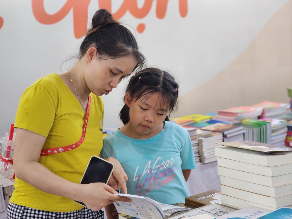 Chị Đặng Thị Hương cùng con chọn sách