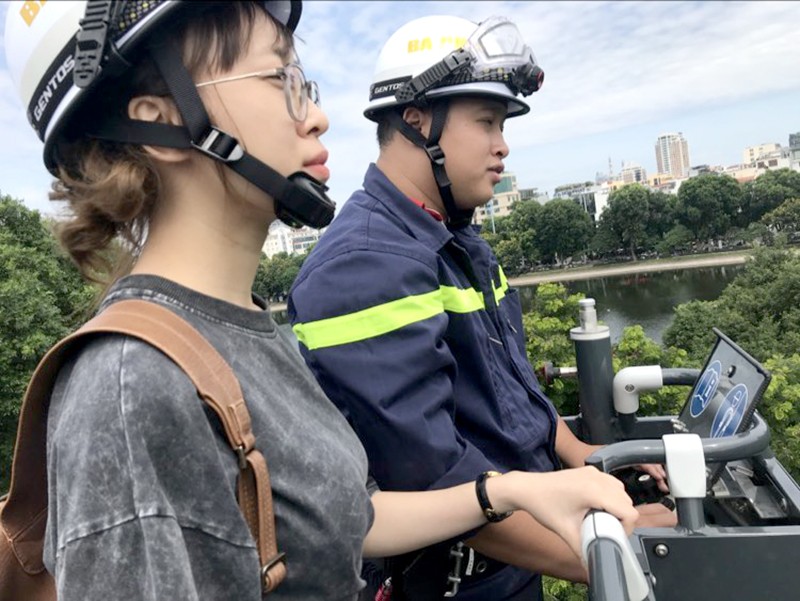 Bạn Quỳnh Anh (20 tuổi sinh viên Đại học Kinh tế quốc dân) được Trung uý Nguyễn Tùng Lộc, Đội Cảnh sát PCCC và CNCH quận Ba Đình cho trải nghiệm xe thang cứu nạn trên tầng cao