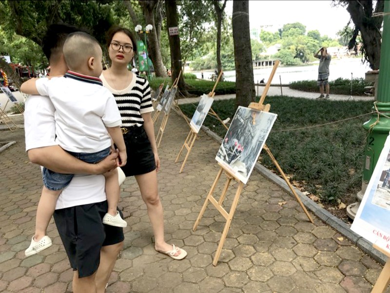 Vợ chồng chị Thuý - Đương ở quận Hà Đông cùng nhiều người dân xem các bức ảnh trưng bày tại buổi trải nghiệm PCCC và CNCH