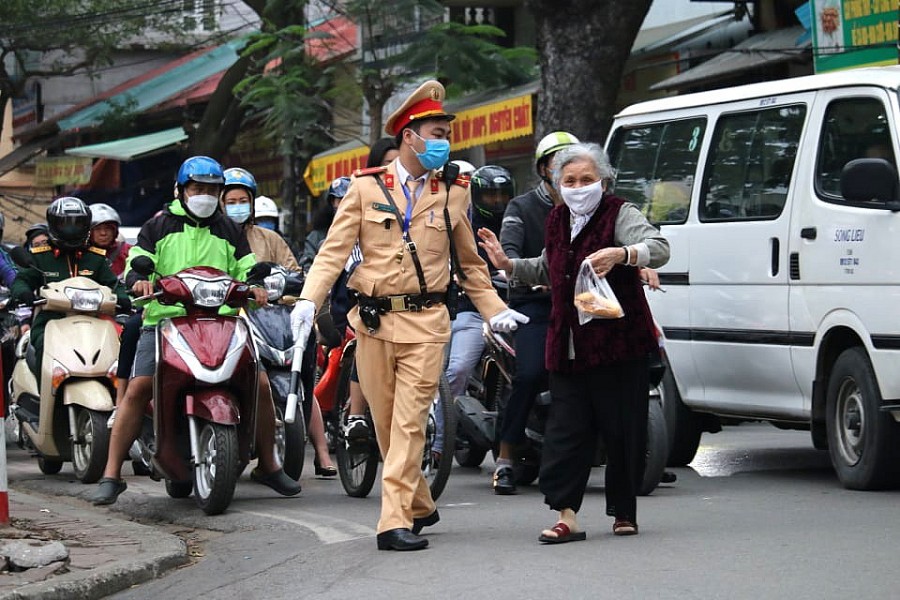 Chiến sĩ cảnh sát giao thông giúp đỡ người già qua đường
