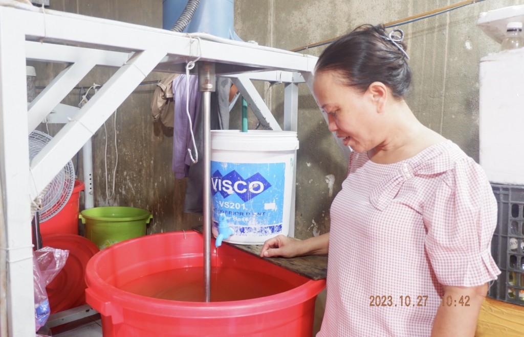 Bà Trịnh Thị Hồng bên chế phẩm sinh học nước lau sàn có nguyên liệu từ 100% rác thải hữu cơ (ảnh Đ.Minh)