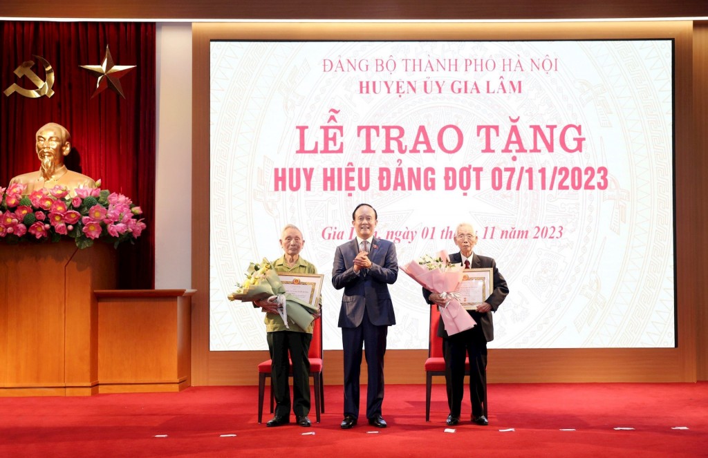 Phó Bí thư Thành ủy, Chủ tịch HĐND thành phố Nguyễn Ngọc Tuấn trao Huy hiệu 75 năm tuổi Đảng tặng các đồng chí Nguyễn Vinh và Phạm Danh Mạch