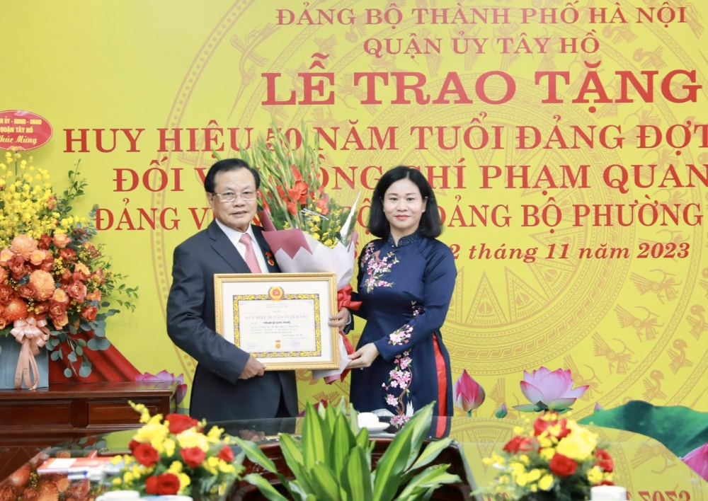 Phó Bí thư Thường trực Thành ủy Nguyễn Thị Tuyến trao Huy hiệu 50 năm tuổi Đảng tặng đồng chí Phạm Quang Nghị.