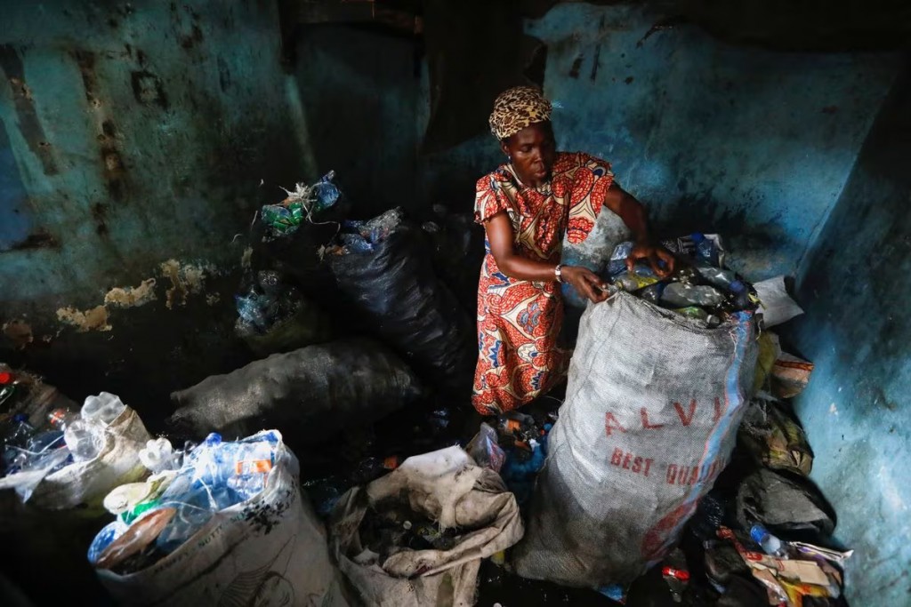 Chị Fatimoh Adeosun, 48 tuổi, phân loại rác thải nhựa để đổi lấy tiền học phí cho con ở Lagos, Nigeria (Ảnh: Reuters)