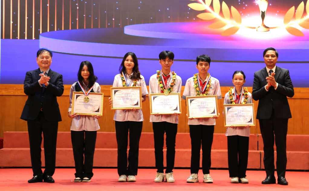 Đồng chí Vũ Văn Diện, Phó Chủ tịch UBND tỉnh Quảng Ninh (bên phải) trao giải Nhất cuộc thi cho các em học sinh.