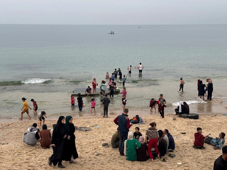 Người Palestine nghỉ ngơi trên bãi biển ở trung tâm Gaza ngày 25/11, một ngày sau khi lệnh ngừng bắn giữa Israel và Hamas có hiệu lực (Ảnh: Reuters)