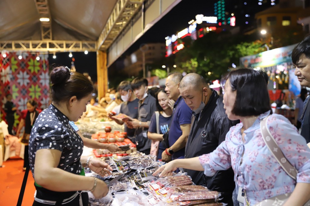 Người dân và du khách tham quan, mua sắm tại gian hàng trưng bày giới thiệu các sản phẩm OCOP, nông sản đặc trưng của các tỉnh Điện Biên, Sơn La, Hà Giang