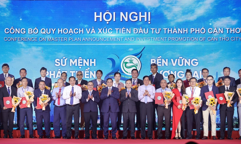 Thủ tướng và lãnh đạo TP. Cần Thơ tặng hoa chúc mừng các doanh nghiệp và đơn vị được trao biên bản ghi nhớ chủ trương đầu tư - Ảnh: VGP/Nhật Bắc