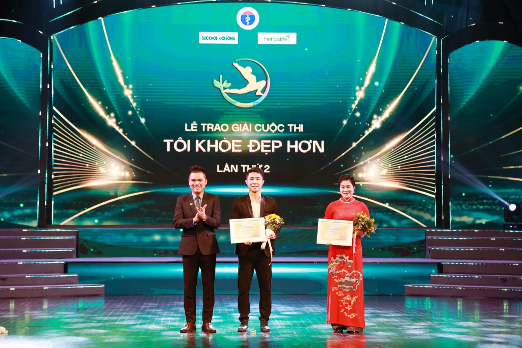 Ông Nguyễn Thành Đạt - Giám đốc Truyền thông Cấp cao Herbalife Việt Nam lên sân khấu trao giấy chứng nhận giải thưởng và tặng hoa cho 2 ứng viên đạt giải. (1)