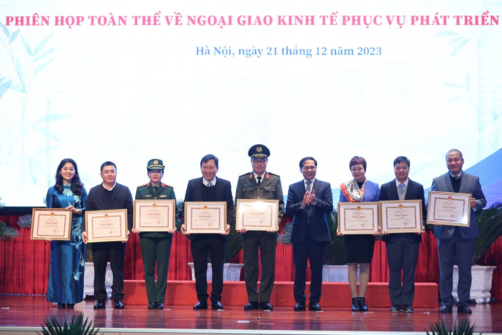 Bộ trưởng Bộ Ngoại giao Bùi Thanh Sơn trao bằng khen cho các tập thể và cá nhân có thành tích xuất sắc - Ảnh: VGP/Nhật Bắc