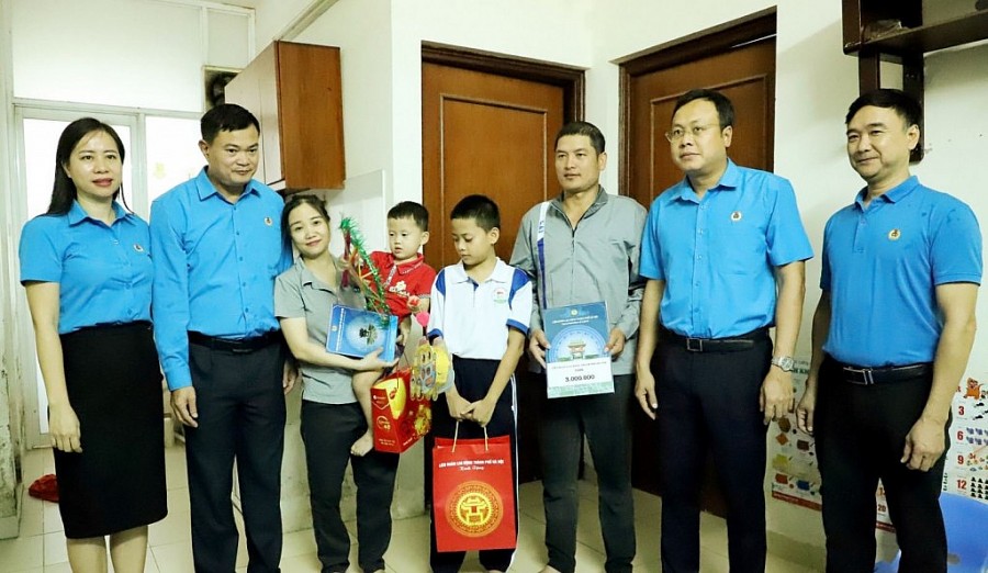 Chủ tịch LĐLĐ thành phố Hà Nội Phạm Quang Thanh (thứ hai từ phải sang) tặng quà cho gia đình chị Nguyễn Thị Hạnh - công nhân Công ty TNHH Kai Việt Nam