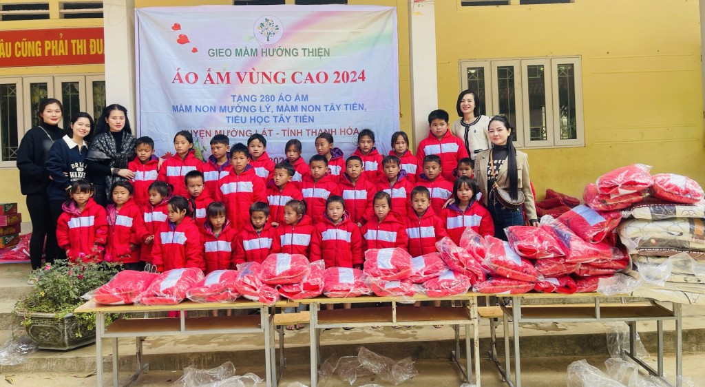 Đoàn thiện nguyện trao tặng áo ấm màu đỏ và quà tới các em học sinh tiểu học