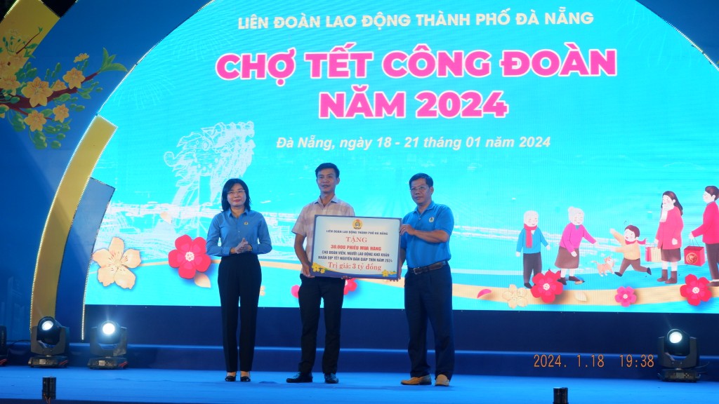 Chủ tịch LĐLĐ TP Đà Nẵng (bên trái) trao tượng trưng 30.000 phiếu mua hàng cho LĐLĐ quận Thanh Khê và Công đoàn Công ty Công viên cây xanh (Ảnh Đ.Minh)
