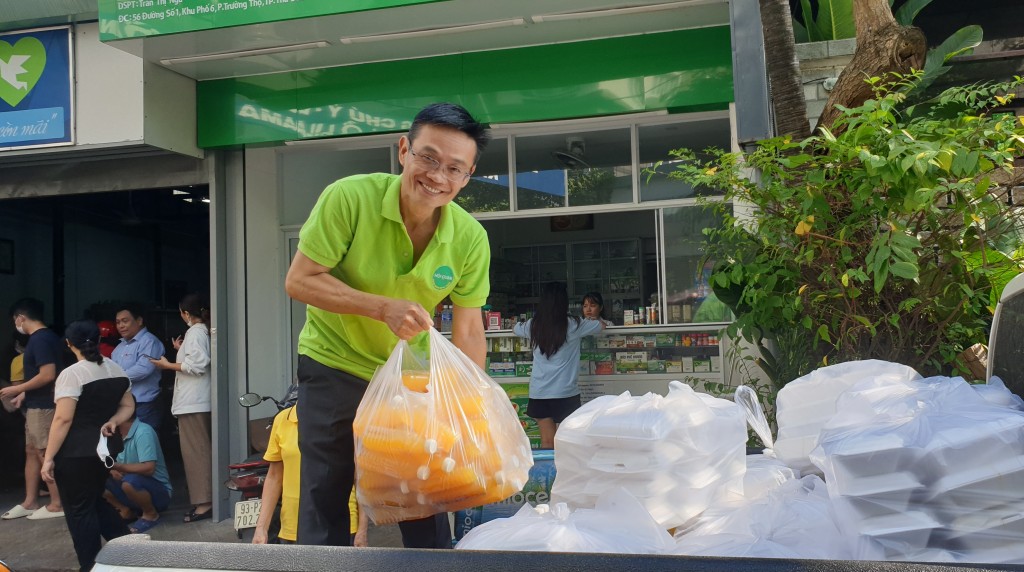 Anh Nguyễn Anh Tuấn đang đưa thức ăn và nước uống lên xe để chuyển đên Bệnh viện Ung Bướu