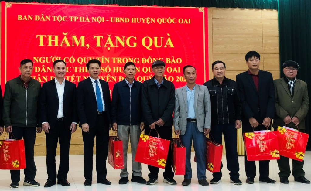 : Trưởng ban Dân tộc thành phố Nguyễn Nguyên Quân (thứ ba bên trái) tặng quà người có uy tín trên địa bàn hai xã Đông Xuân và Phú Mãn (huyện Quốc Oai)