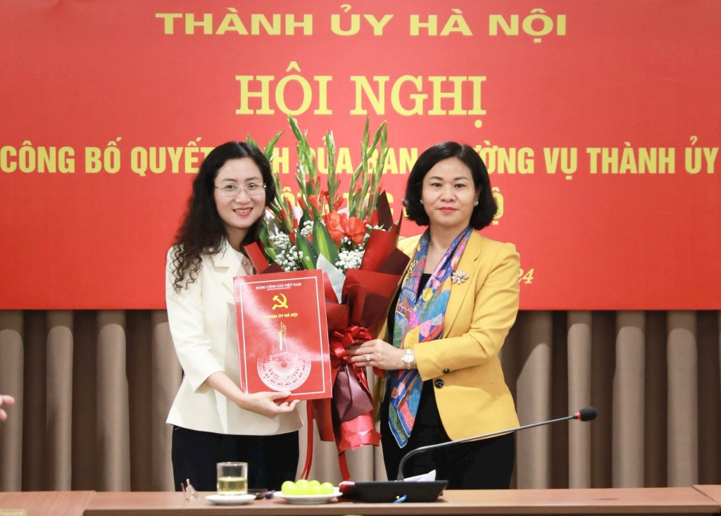 Phó Bí thư Thường trực Thành ủy Nguyễn Thị Tuyến trao quyết định, tặng hoa chúc mừng đồng chí Nguyễn Thị Huệ.