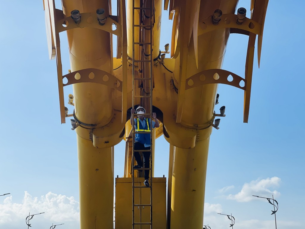 Để kiểm tra đường ống phun lửa và phun nước bên trong đầu rồng, các kỹ sư leo lên chiếc thang dài khoảng 10m (Ảnh Đ.Minh)