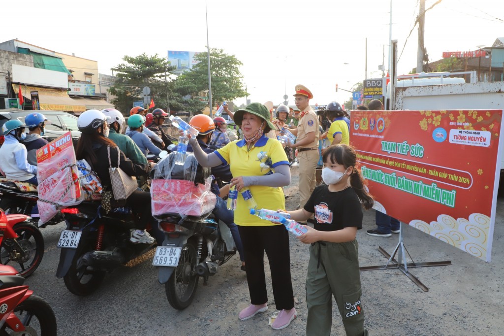 Những em nhỏ cũng hào hứng khi tặng nước các anh chị, cô chú về quê