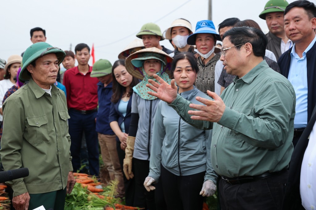 Thủ tướng nói chuyện, động viên bà con nông dân ngay trên ruộng cà rốt vừa thu hoạch - Ảnh: VGP/Nhật Bắc
