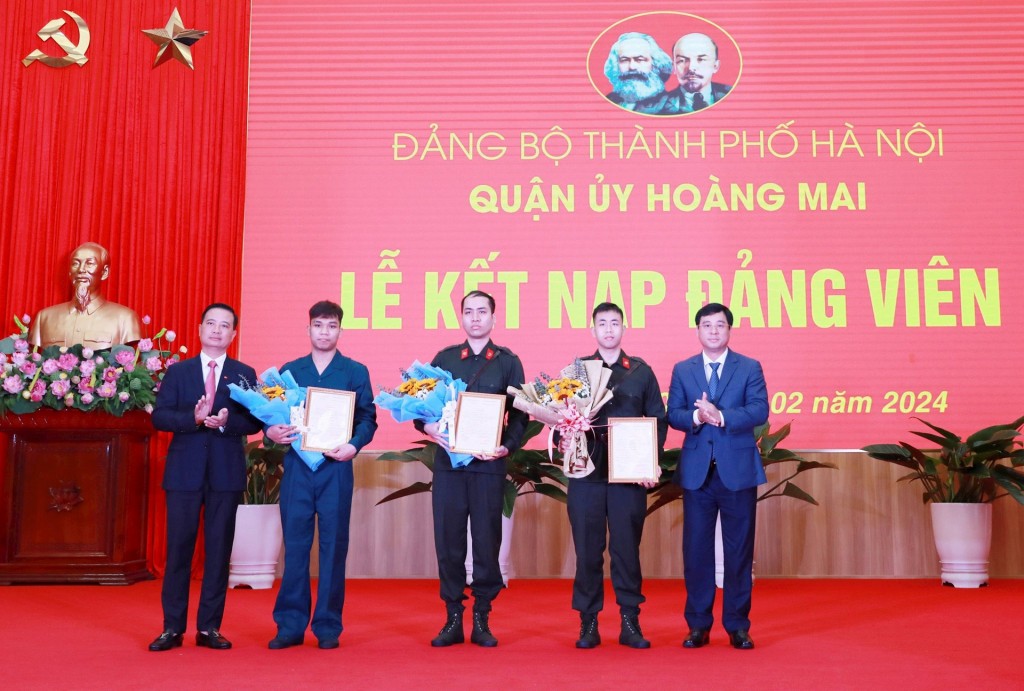 Bí thư Quận ủy Hoàng Mai Nguyễn Xuân Linh và Chủ tịch UBND quận Hoàng Mai Nguyễn Minh Tâm trao quyết định và tặng hoa cho các đảng viên mới