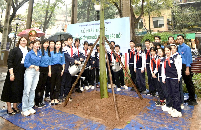 Các em học sinh cùng đoàn viên thanh niên phường Hàng Trống chụp ảnh lưu niệm bên canh xanh mới được trồng