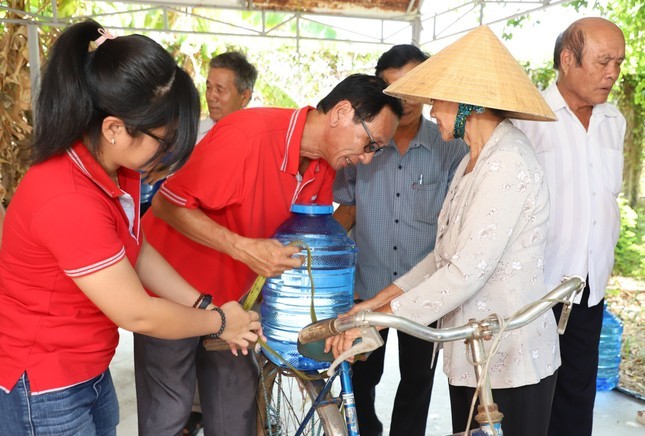 Tình nguyện viên hỗ trợ người dân mang nước sạch về nhà