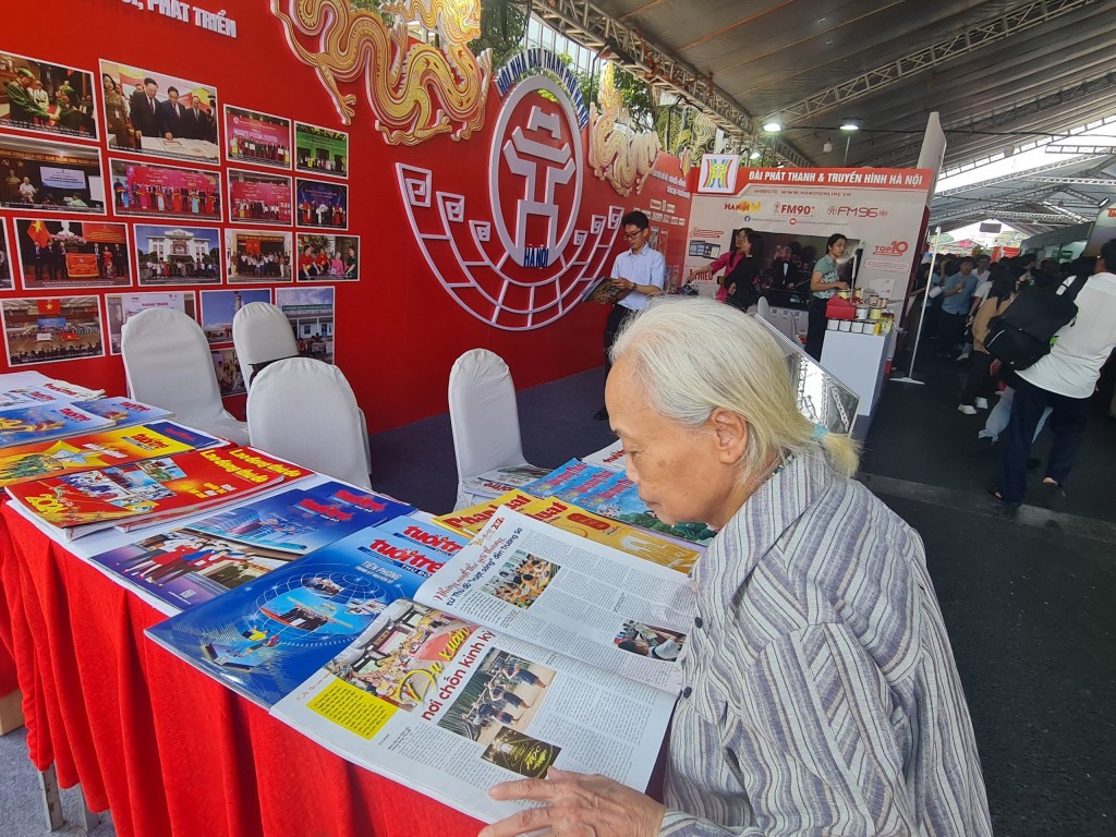 Cụ Nguyễn Thị Thiều (80 tuổi) nán lại hồi lâu để ngắm nhìn tờ báo mình yêu thích (báo Phụ Nữ Thủ đô và Tuổi trẻ Thủ đô)