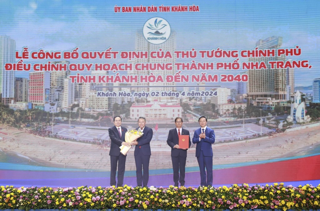 Phó Chủ tịch Thường trực Quốc hội Trần Thanh Mẫn (bìa trái) và Phó Thủ tướng Trần Hồng Hà tặng hoa, trao quyết định của Thủ tướng Chính phủ điều chỉnh Quy hoạch chung thành phố Nha Trang đến năm 2040 cho lãnh đạo tỉnh Khánh Hòa - Ảnh: Báo Khánh Hòa