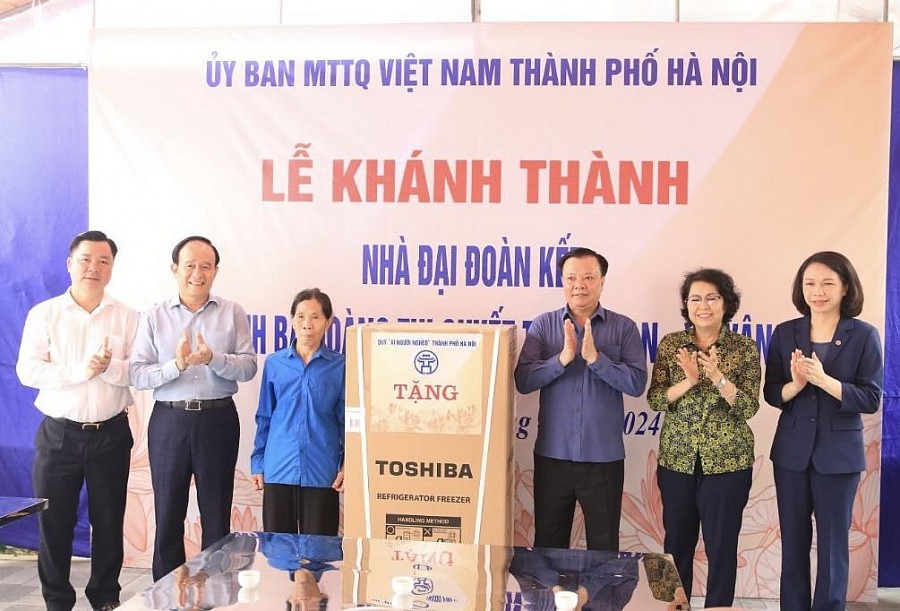 Bí thư Thành ủy Đinh Tiến Dũng cùng các đồng chí lãnh đạo trao quà mừng nhà mới của thành phố tặng gia đình bà Hoàng Thị Quyết.