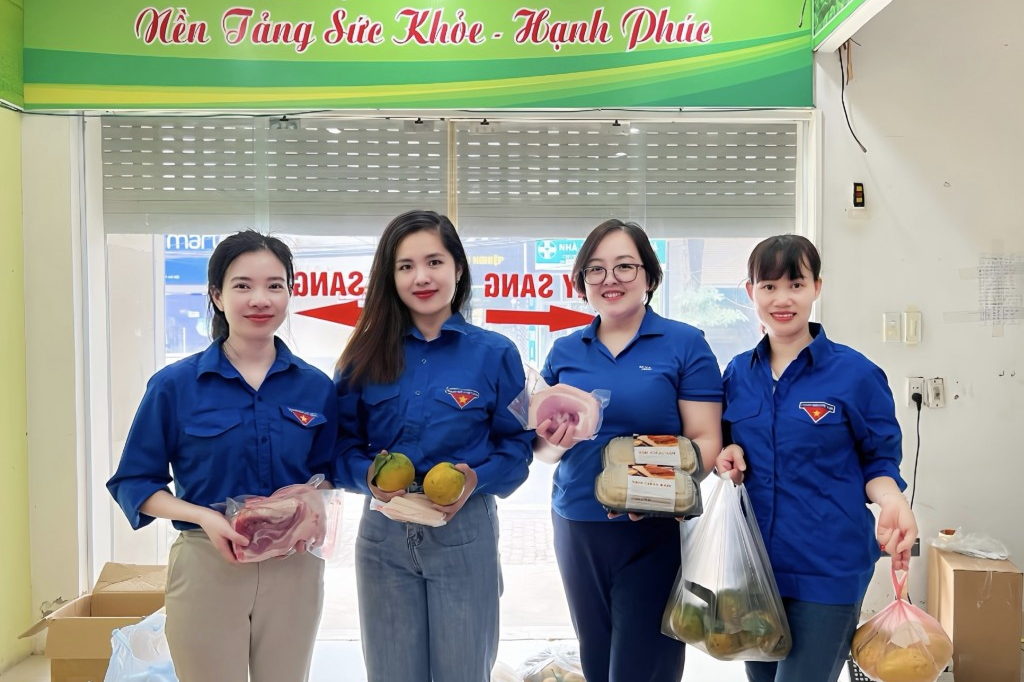 Nguyễn Hoàng Anh (thứ hai từ trái sang) cùng đoàn viên, thanh niên hỗ trợ nông dân tiêu thụ nông sản