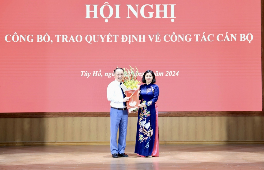 Phó Bí thư Thường trực Thành ủy Hà Nội Nguyễn Thị Tuyến trao Quyết định và tặng hoa chúc mừng đồng chí Nguyễn Lê Hoàng.