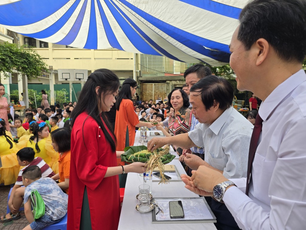 Thức quà nổi tiếng của Hà Nội: Cốm Làng Vòng được học sinh mời đại biểu và khán giả thưởng thức