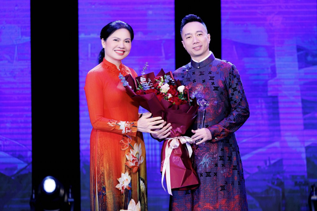 NTK Đỗ Trịnh Hoài Nam - đại diện SVF Academy nhận hoa từ Chủ tịch Hội Phụ nữ Việt Nam Hà Thị Nga tặng tại đêm khai mạc Tuần lễ Áo dài Việt Nam