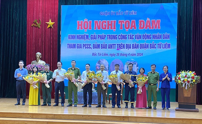 Lãnh đạo Quận uỷ Bắc Từ Liêm tặng hoa cho các đại biểu, đại diện lãnh đạo các đơn vị tham gia toạ đàm