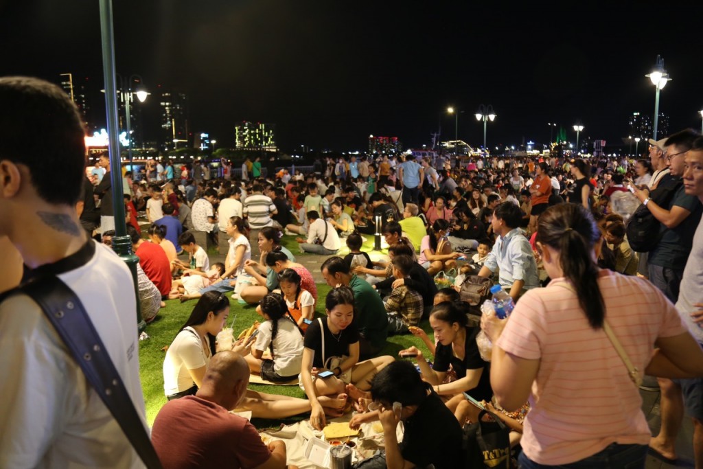 Tại khu vực bến Bạch Đằng, nhiều người tranh thủ trải bạt, tìm một chỗ ngồi ưng ý để ăn uống, vui chơi, trò chuyện trong lúc chờ pháo hoa lúc 21 giờ.