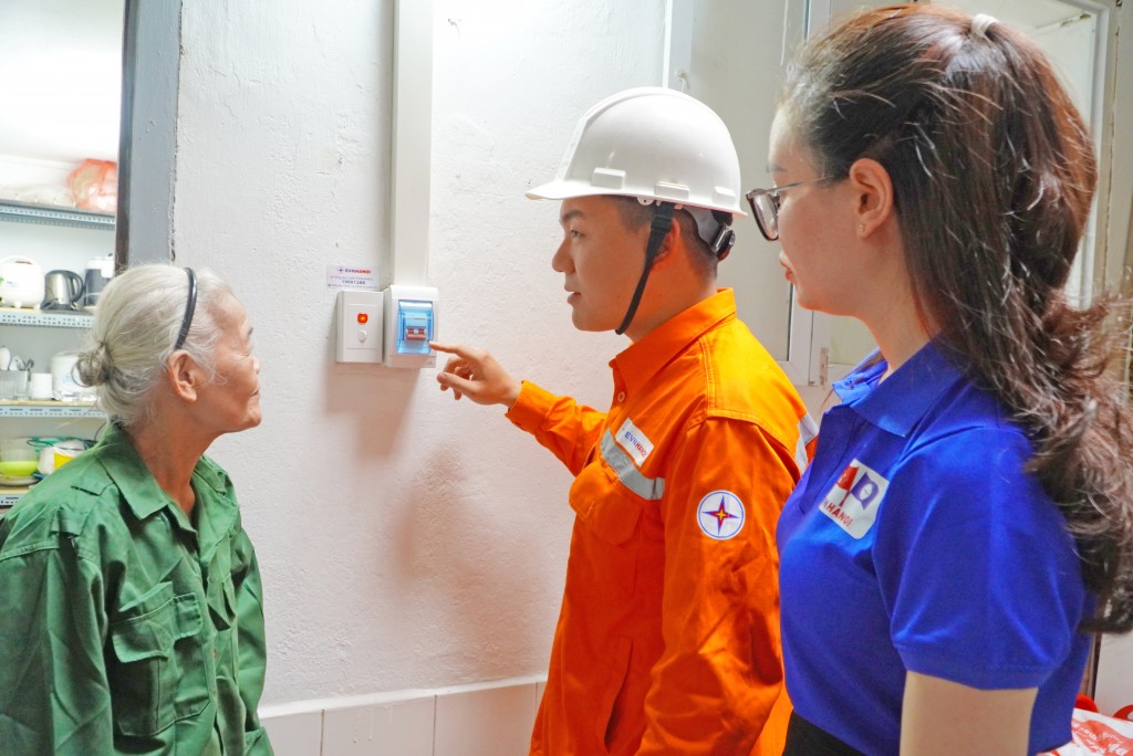 Đoàn viên, thanh niên EVN Hà Nội hướng dẫn bà Huệ sử dụng các thiết bị điện an toàn