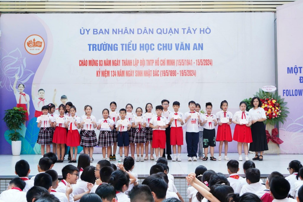 Các bạn đội viên trường Tiểu học Chu Văn An xúc động khi nhận được tấm huy hiệu Đội