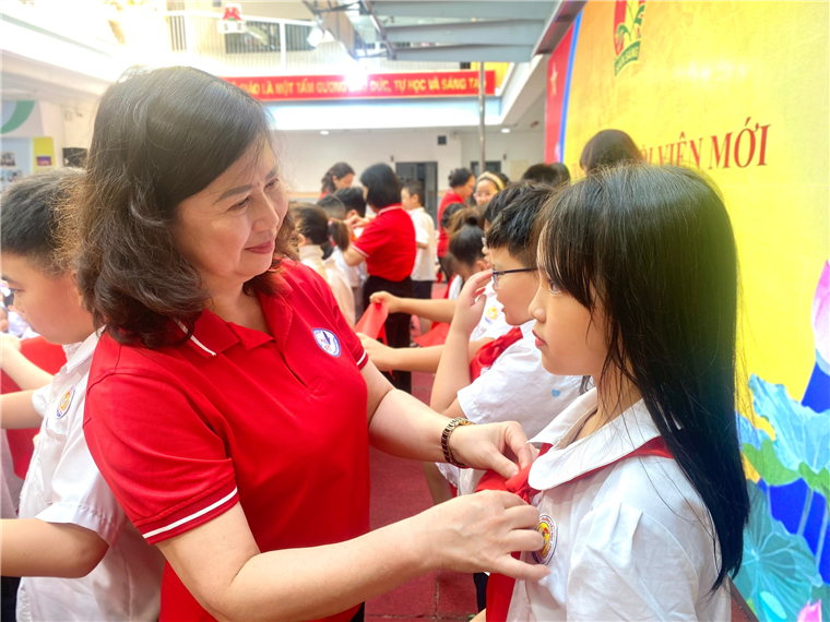 Cô giáo Hoàng Thị Lan Hương – Bí thư chi bộ, Hiệu trưởng nhà trường  trao khăn quàng đổ cho các đội viên xuất sắc