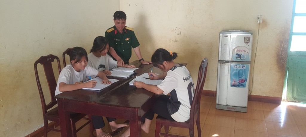 Cán bộ Trung đoàn 720 dạy các cháu đồng bào Mông mồ côi học bài