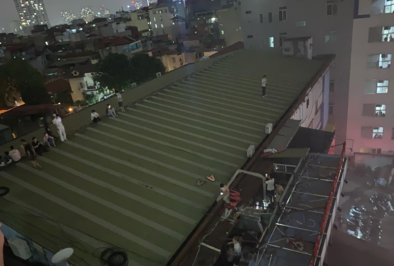 Nhiều người dân trèo lên mái nhà tránh khói lửa, chờ lực lượng cứu hộ