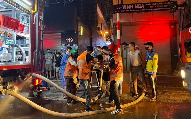 Các nạn ngân được đưa ra ngoài trong vụ cháy rạng sáng 24/5 tại Trung Kính (Cầu Giấy, Hà Nội). (Ảnh: Vietnam+)